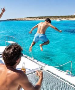 Amigos saltando al mar desde un catamarán en Formentera